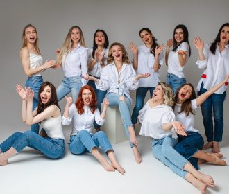 Women solidarity concept. Happy young female team stylish staff posing for group studio photography, girls wearing jeans. High quality photo